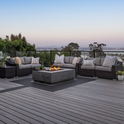 modern glass filled railing surrounding deck with chairs and a fire pit