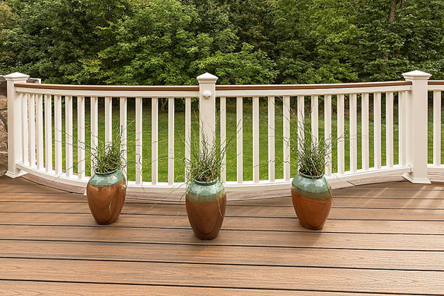 Trex Transcend Tiki Torch and white curved railing. Deck colour is Vintage Lantern 