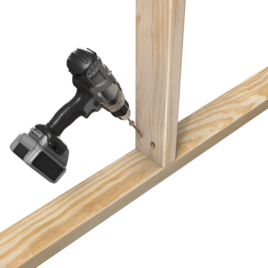 drilling a screw into wood framing