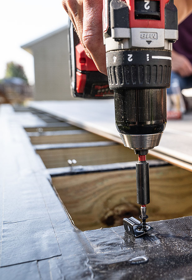 starter clip being screwed into joist